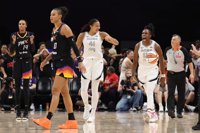 Chelsea Gray #12 of the Las Vegas Aces celebrates with Kiah Stokes #41 after stealing an inbound pass during the final moments of the WNBA game against the Phoenix Mercury at PHX Arena on August 15, 2025 in Phoenix, Arizona. The Aces defeated the Mercury 86-83.