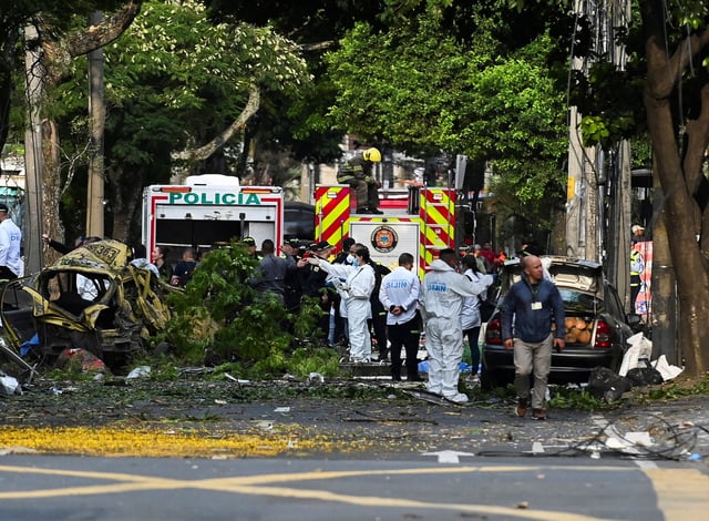 Security forces and forensic team members work next to debris following the explosion of a cargo vehicle near an Aerospace Force base, in one of two attacks attributed to FARC dissident groups, that caused multiple casualties, according to authorities, in Cali, Colombia August 21, 2025. REUTERS/Oswaldo Paez
