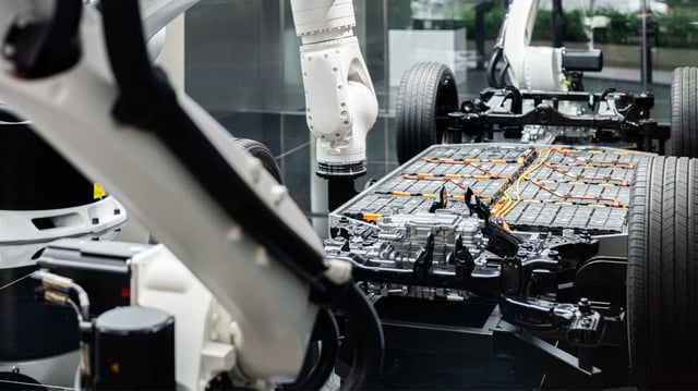 Electric car battery installation using a robotic arm for futuristic vehicle assembly