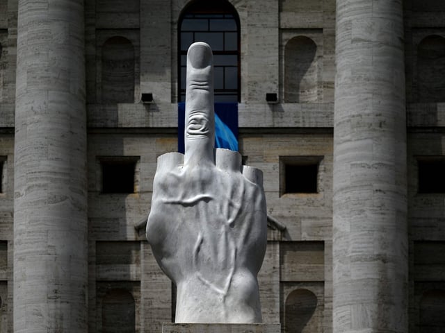 Escultura de 2010 del artista italiano Maurizio Cattelan, titulada «L.O.V.E» («Il Dito»), aparece frente al Palazzo Mezzanotte, el edificio de la bolsa de valores de Italia, el 6 de junio de 2023 en Milán. El nombre L.O.V.E. es el acrónimo de «Libertà, Odio, Vendetta, Eternità» («Libertad, Odio, Venganza, Eternidad»). 
GABRIEL BOUYS / AFP


