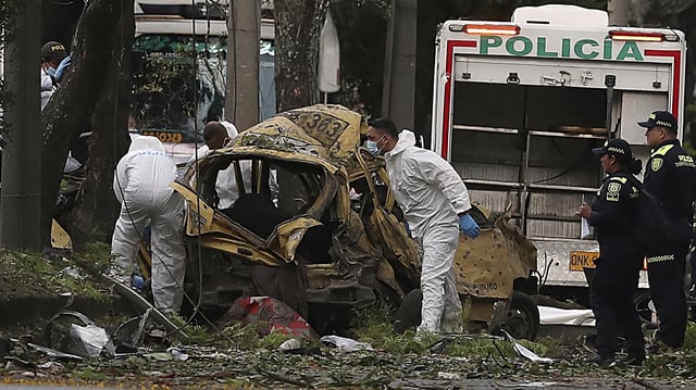Forensiker inspizieren die Trümmer nach einem Anschlag in Cali.