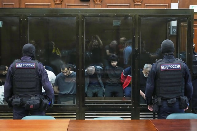 FILE - Suspects accused of involvement in a shooting and arson attack on a concert on March 22, 2024, sit in a defendants’ cage before a hearing in the 2nd Western District Military Court in Moscow, Russia, Monday, Aug. 4, 2025. (AP Photo/Pavel Bednyakov, File)