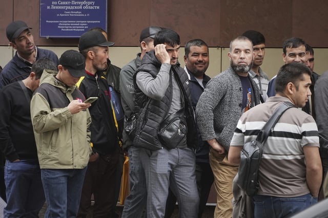 People stand in line to enter a center for government services in St. Petersburg, Russia, Monday, Aug. 11, 2025. (AP Photo/Dmitri Lovetsky)