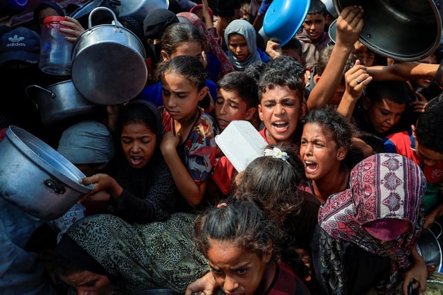 Palestinians wait to receive food from a charity kitchen, in Khan Younis, southern Gaza Strip, August 21, 2025. REUTERS/Hatem Khaled/File Photo