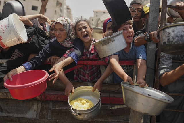 FILE - Palestinians struggle to get donated food at a community kitchen in Gaza City, northern Gaza Strip, Saturday, Aug. 16, 2025. (AP Photo/Jehad Alshrafi, File)