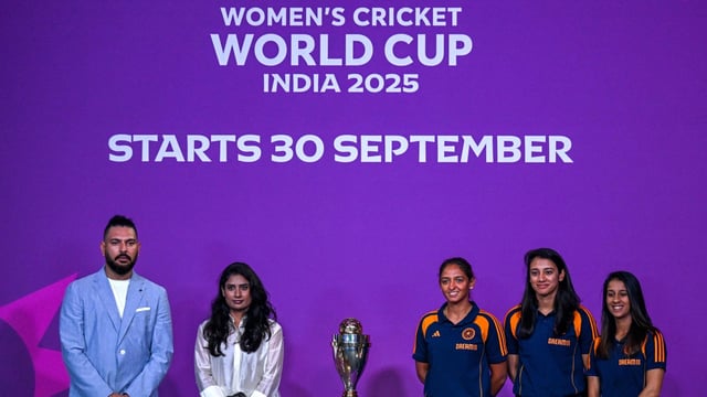 Indian team players Jemimah Rodrigues (R), Smriti Mandhana (2R) and Harmanpreet Kaur (C) pose with the trophy alongside former player Yuvraj Singh (L)