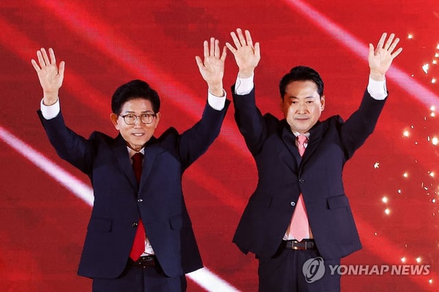 Former Labor Minister Kim Moon-soo (L) and Rep. Jang Dong-hyeok, candidates for the main opposition People Power Party's leadership race, pose for a photo as they advanced to a runoff at the party's national convention in the city of Cheongju, North Chungcheong Province, on Aug. 22, 2025. (Pool photo) (Yonhap)