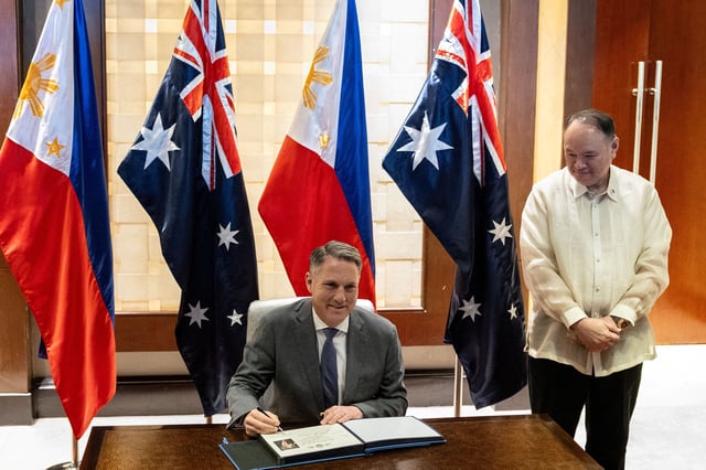 Philippine Defence Minister Gilberto Teodoro looks on as his Australian counterpart Richard Marles signs a guest book ahead of their bilateral meeting in Makati City, Metro Manila, Philippines, August 22, 2025. REUTERS/Eloisa Lopez