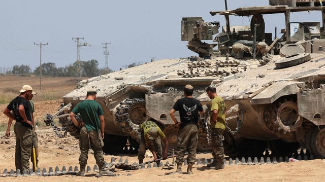 Israelische Soldaten schauen sich an der Grenze zum Gazastreifen eine Pankzerkette an.