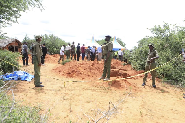 FILE - Police officers stand near a cordon at the scene where bodies of victims of a Christian cult are being exhumed in a forest in the Shakahola area, near Malindi town, Kenya, Tuesday, April 25, 2023. (AP Photo/File)