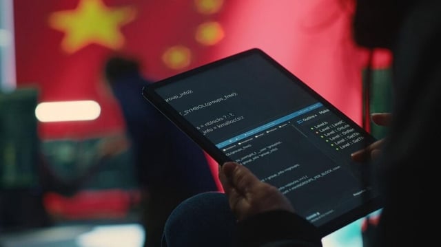 A person with a tab in front of the Chinese flag.