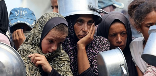 Des Palestiniens attendent une distribution de repas à Khan Younès, dans le sud de la bande de Gaza, le 21 août 2025