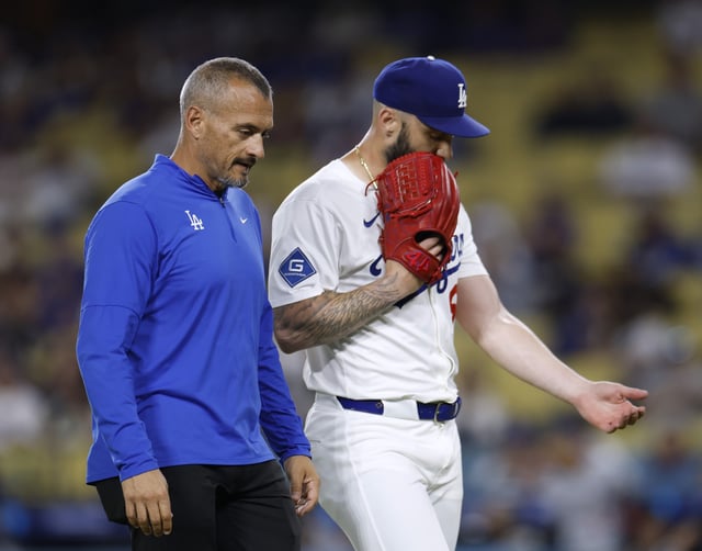 LOS ANGELES, CALIFORNIA - JULY 21: Tanner Scott #66 of the Los Angeles Dodgers reacts as he leaves the game with medical staff during the ninth inning against the Minnesota Twins at Dodger Stadium on July 21, 2025 in Los Angeles, California.