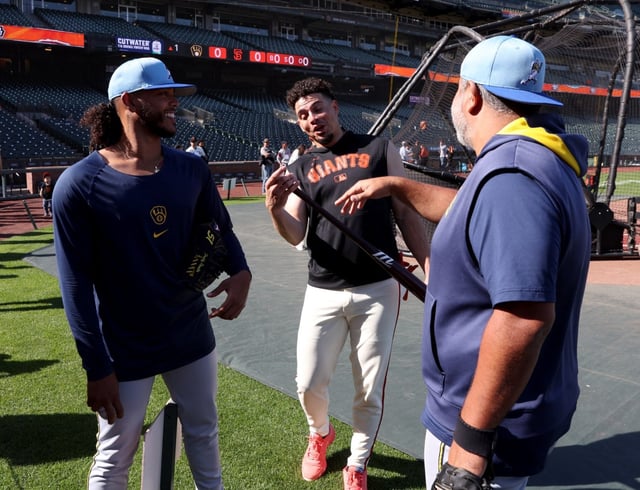 San Francisco Giants shortstop Willy Adames #2 jokes with Milwaukee Brewers pitcher Freddy Peralta #51 and field coordinator Néstor Corredor, right, during batting practice before their MLB game at Oracle Park in San Francisco, Calif., on Monday, April 21, 2025. (Jane Tyska/Bay Area News Group)