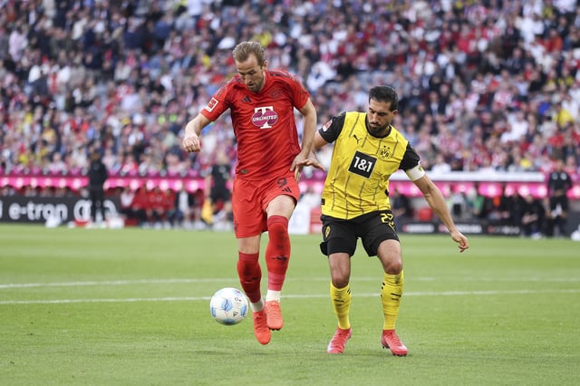 Emre Can of Borussia Dortmund battles for possession with Harry Kane of Bayern München during the Bundesliga match between FC Bayern München and Borussia Dortmund at Allianz Arena on April 12, 2025, in Munich, Germany.