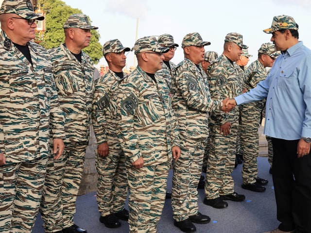 AME2567. CARACAS (VENEZUELA), 21/08/2025.- Fotografía cedida por prensa del Palacio de Miraflores del presidente de Venezuela, Nicolás Maduro (d), saludando a miembros de la Milicia Bolivariana este jueves, en Caracas (Venezuela). Maduro convocó a una jornada de alistamiento de las "fuerzas milicianas" durante el fin de semana, en respuesta al patrullaje de buques que planteó Estados Unidos en el mar Caribe, cerca del país suramericano, para combatir el narcotráfico. EFE/ Palacio de Miraflores /SOLO USO EDITORIAL/ NO VENTAS/ SOLO DISPONIBLE PARA ILUSTRAR LA NOTICIA QUE ACOMPAÑA (CRÉDITO OBLIGATORIO)
