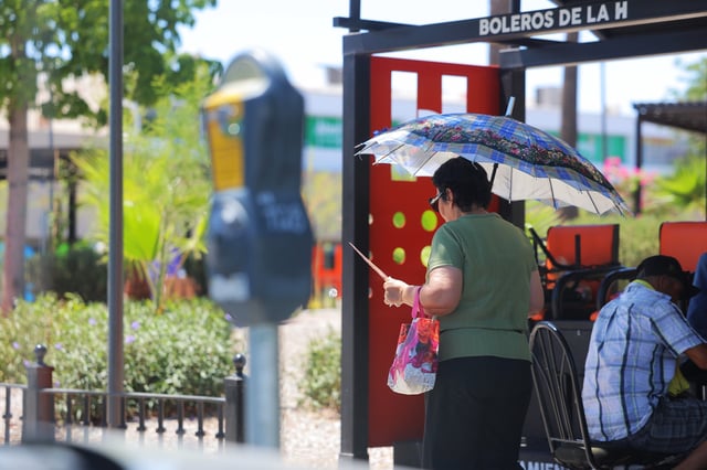 Una mujer se protege del sol con sombrilla en el Centro de Hermosillo, donde se pronostican temperaturas extremas durante el fin de semana. FOTO: BANCO DIGITAL