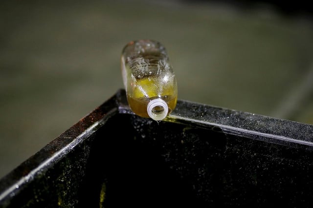 Speiseölflasche auf dem Rand eines großen Öltanks