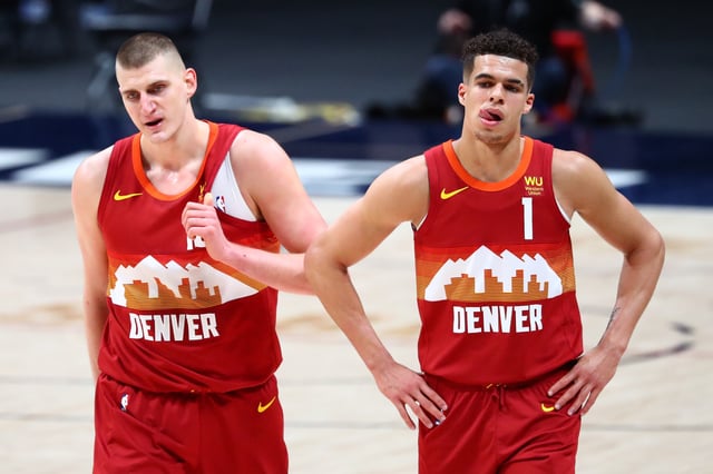 Nikola Jokic #15 and Michael Porter Jr. #1 of the Denver Nuggets walk toward the locker room during halftime of their game against the New Orleans Pelicans at Ball Arena on April 28, 2021 in Denver, Colorado.