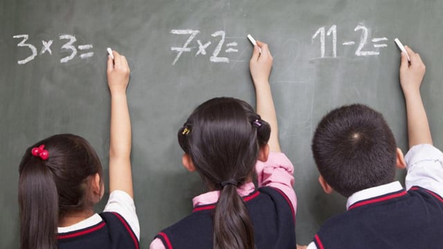 Three school children doing math equations on the blackboard (Getty Images/iStockphoto)