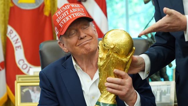 President Donald Trump holds the FIFA World Cup Winners Trophy during an announcement in the Oval Office 