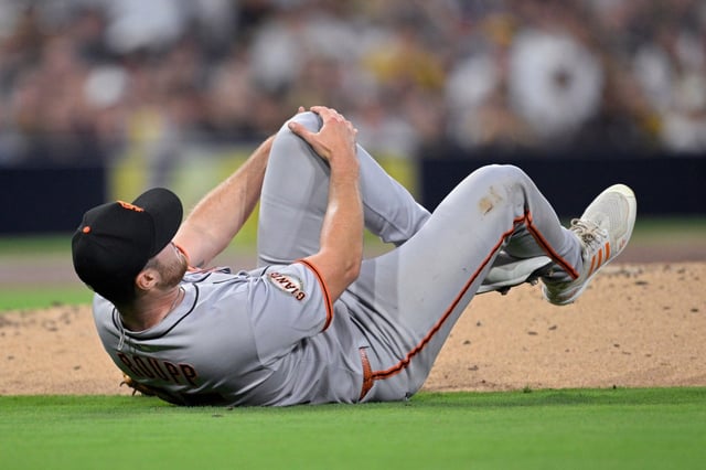 San Francisco Giants starting pitcher Landen Roupp reacts after being hit by a line drive during the third inning of a baseball game against the San Diego Padres Wednesday, Aug. 20, 2025, in San Diego. (AP Photo/Orlando Ramirez)