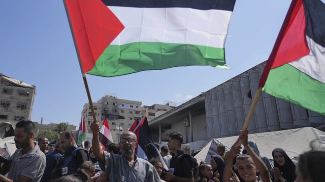 Palestinians take part in a protest calling for the end of the war in the Gaza Strip as they gather at a tent camp for displaced people, in Gaza City, Thursday, Aug, 21, 2025. (AP Photo/Abdel Kareem Hana)