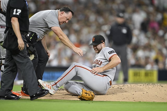 Aug 20, 2025; San Diego, California, USA; San Francisco Giants starting pitcher Landen Roupp (65) is looked at by a trainer after being hit by a ball hit by San Diego Padres right fielder Ramon Laureano (5) during the third inning at Petco Park. Mandatory Credit: Denis Poroy-Imagn Images