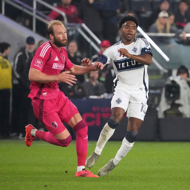 St. Louis City's João Klauss, left, and Vancouver Whitecaps' Ralph Priso (13) challenge for the ball during the second half of an MLS soccer match Saturday, April 19, 2025, in St. Louis. (AP Photo/Jeff Roberson)
