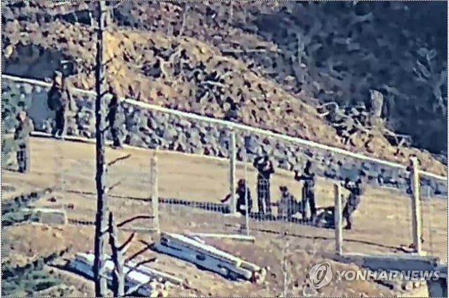 This photo, provided by South Korea's Joint Chiefs of Staff on Dec. 23, 2024, shows North Korean soldiers seen installing barbed-wire fences in border areas. (PHOTO NOT FOR SALE) (Yonhap)