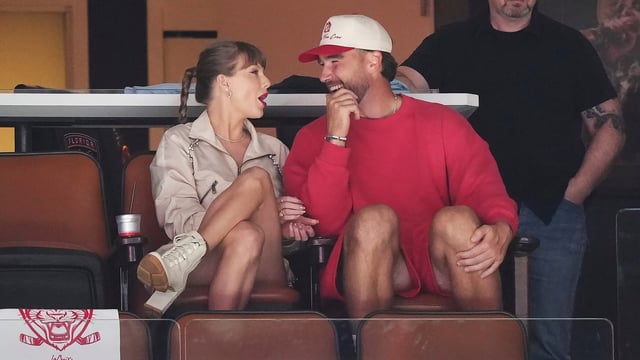 Singer Taylor Swift, left, and Kansas City Chiefs football player Travis Kelce, front right, at an NHL game