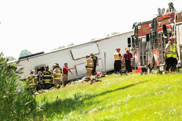 Bomberos y agentes en el sitio donde un autobús turístico se estrelló en la autopista Interestatal 90 cerca de Pembroke, Nueva York, el viernes 22 de agosto de 2025. (Libby March/The Buffalo News via AP)