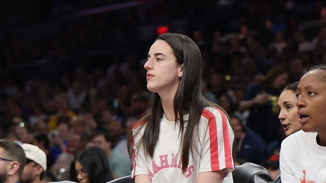 Caitlin Clark #22 of the Indiana Fever watches from the bench during the first half of the WNBA game against the Phoenix Mercury 