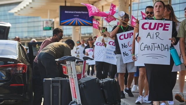 Travellers pass Air Canada flight attendants on strike at Pearson International Airport in Toronto on Monday. Air Canada passengers whose fights have been cancelled due to the strike have a right to a booked flight — if one is available. 