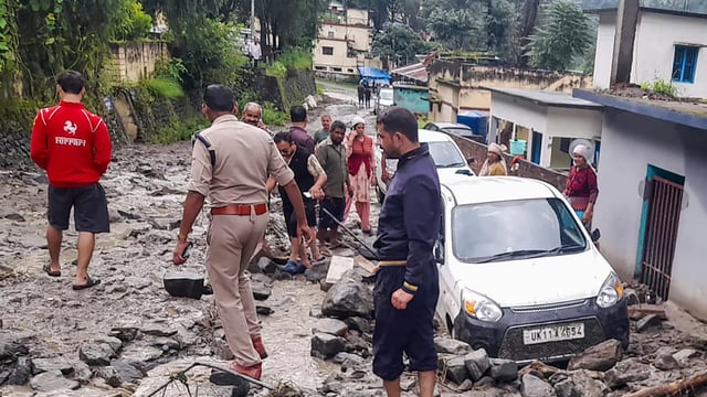 A police official and others during a search and rescue operation at an affected area after heavy rainfall in Chamoli district, Uttarakhand. 