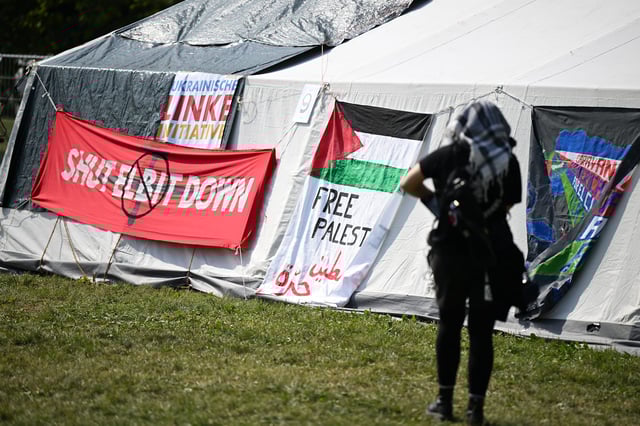 Im „System Change Camp“ für Klimagerechtigkeit hängen auch Plakate mit der Aufschrift „Free Palestine“ und „Shut Elbit down“. Elbit ist ein israelischer Rüstungskonzern
