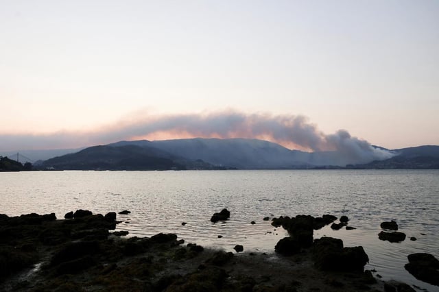 De la fumée s’élève d’un incendie de forêt dans les montagnes de Santa Cristina de Cobres, près de Vigo, dans la province de Pontevedra en Espagne, le 21 août 2025.
