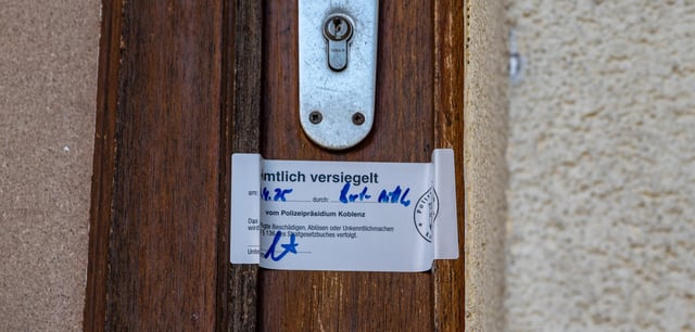 Ein Polizeisiegel an der Haustür, hinter der in der Nacht zum Sonntag, den 6. April 2025 drei Menschen starben