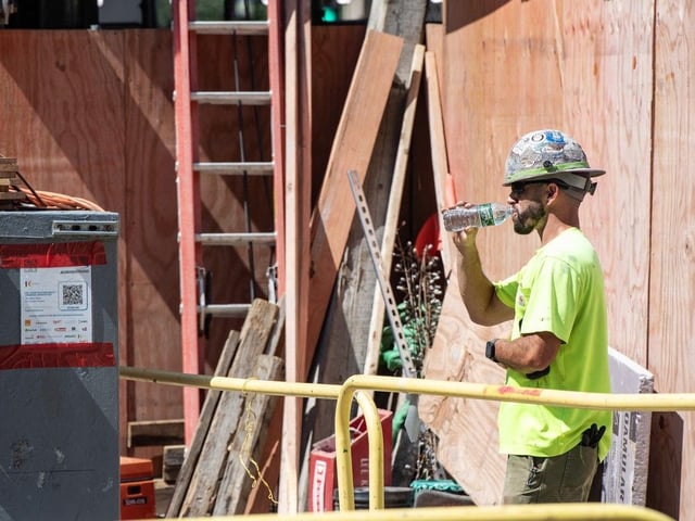 File photo of a construction worker drinking water during a heat wave. Photo: AFP.