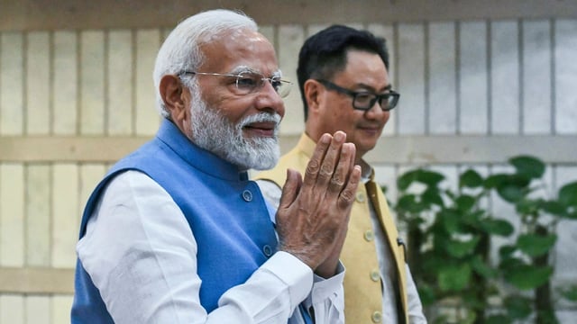 Prime Minister Narendra Modi with Union minister Kiren Rijiju in the Parliament in New Delhi