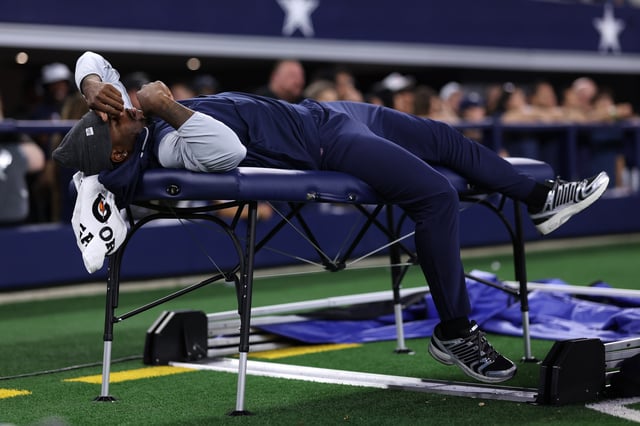 Micah Parsons #11 of the Dallas Cowboys lays on a training table during the second half of the NFL Preseason 2025 game against the Atlanta Falcons at AT&T Stadium on August 22, 2025 in Arlington, Texas.