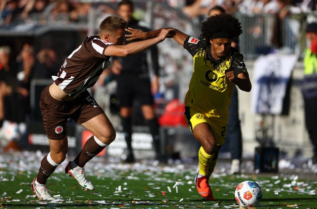 Soccer Football - Bundesliga - St. Pauli v Borussia Dortmund - Millerntor-Stadion, Hamburg, Germany - August 23, 2025  Borussia Dortmund's Karim Adeyemi in action with St. Pauli's Hauke Wahl REUTERS/Lisi Niesner