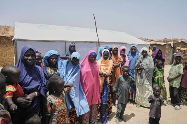 FILE - Women and children displaced by Boko Haram attacks are seen outside their camp in Dikwa, northeast Nigeria, on April 29, 2025. (AP Photo/Sunday Alamba, File)