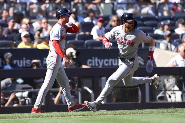 Trevor Story de los Medias Rojas de Boston corre al plato en un sencillo de Ceddanne Rafaela frente al entrenador de tercera base Kyle Hudson en la novena entrada del juego ante los Yankees de Nueva York el sábado 23 de agosto del 2025. (AP Foto/Pamela Smith)