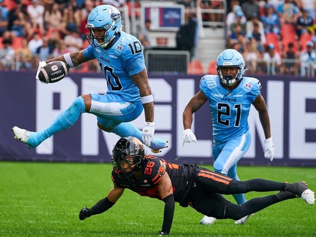 Toronto Argonauts wide receiver Kevin Mital  evades a tackle from B.C. Lions defensive back Robert Carter Jr.  as Toronto Argonauts running back Spencer Brown  chases during game in Toronto, Aug. 23, 2025.