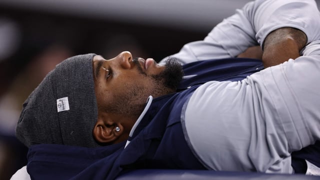 Micah Parsons #11 of the Dallas Cowboys lays on a training table during the second half vs Falcons