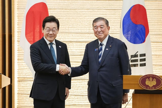 Japanese Prime Minister Shigeru Ishiba shakes hands with South Korean President Lee Jae Myung after meeting the press following their talks at the prime minister's office in Tokyo on August 23, 2025.
