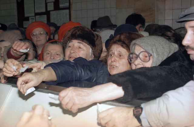 FILE - Ukrainian women shout while waving their coupons to buy butter at a state-owned shop in Kyiv, Dec. 3, 1991. (AP Photo/Liu Heung Shing, File)