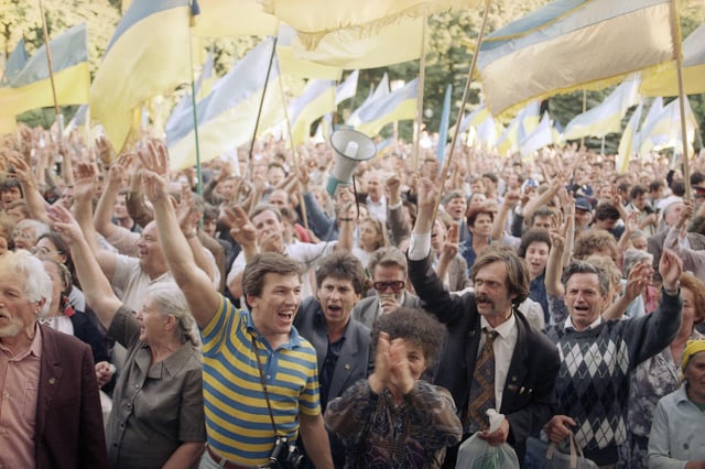 FILE - People wave Ukrainian national flags as they gather outside the parliament building during a pro-independence rally, in Kyiv, Sept. 4, 1991. (AP Photo/Dusan Vranic, File)