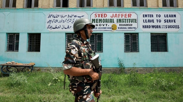 A member of Indian security forces patrols outside Syed Jaffer Memorial School, run by Falah-e-Aam Trust (FAT), an affiliate of Kashmir-based Islamist political party Jamaat-e-Islami (JeI), which was banned. 